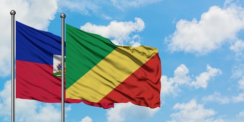 Haiti and Republic Of The Congo flag waving in the wind against white cloudy blue sky together. Diplomacy concept, international relations.