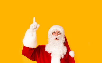 Santa Claus looking surprised and showing with finger on copy space