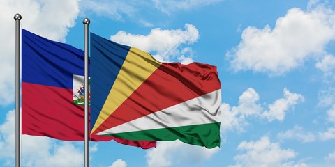 Haiti and Seychelles flag waving in the wind against white cloudy blue sky together. Diplomacy concept, international relations.