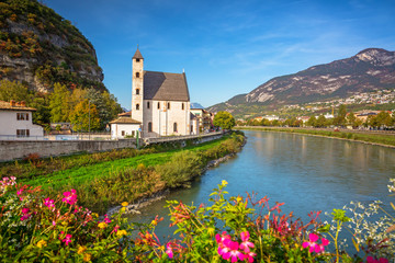 Beautiful scenery of Trento city with Saint Apollinare church at Adige river, Northern Italy