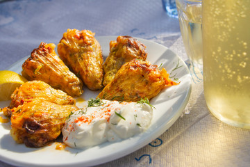 Greek traditional gemista, stuffed tomatoes and peppers on a white plate served in taverna with retsina, Greece