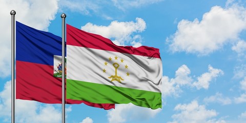 Haiti and Tajikistan flag waving in the wind against white cloudy blue sky together. Diplomacy concept, international relations.