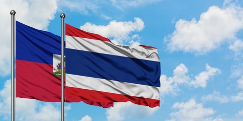 Haiti and Thailand flag waving in the wind against white cloudy blue sky together. Diplomacy concept, international relations.