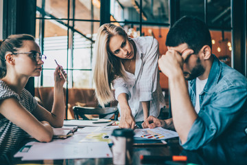 Young colleagues with papers in cafe