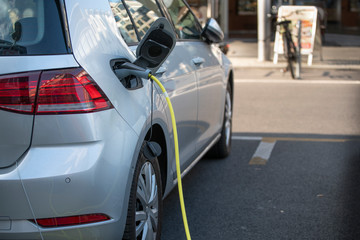 charging the electric car silver color. Power supply for electric vehicle charging. car charging cable.