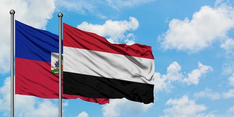 Haiti and Yemen flag waving in the wind against white cloudy blue sky together. Diplomacy concept, international relations.