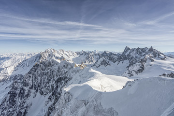 Fototapeta na wymiar Skier hiker slowy walk down on a massive snow mountain slope on top of alps mont blanc