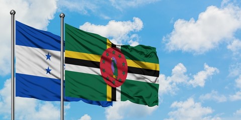 Honduras and Dominica flag waving in the wind against white cloudy blue sky together. Diplomacy concept, international relations.