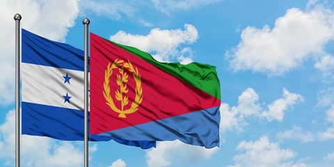 Honduras and Eritrea flag waving in the wind against white cloudy blue sky together. Diplomacy concept, international relations.