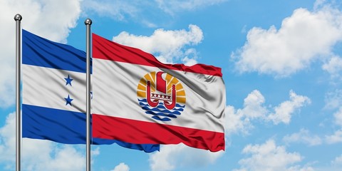 Honduras and French Polynesia flag waving in the wind against white cloudy blue sky together. Diplomacy concept, international relations.