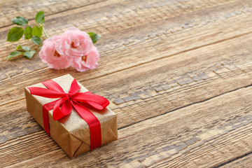 Gift box on wooden boards with rose flowers