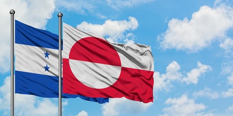 Honduras and Greenland flag waving in the wind against white cloudy blue sky together. Diplomacy concept, international relations.