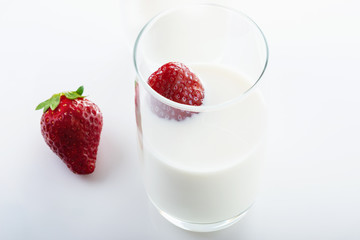 Fresh, juicy strawberry in cream on white background. Close up. Selective focus. High key.