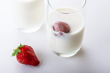 Fresh, juicy strawberry in cream on white background. Close up. Selective focus. High key.