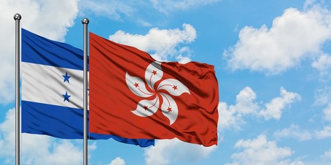 Honduras and Hong Kong flag waving in the wind against white cloudy blue sky together. Diplomacy concept, international relations.