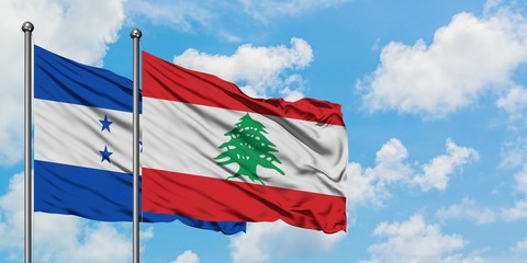 Honduras and Lebanon flag waving in the wind against white cloudy blue sky together. Diplomacy concept, international relations.