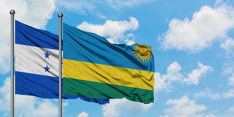Honduras and Rwanda flag waving in the wind against white cloudy blue sky together. Diplomacy concept, international relations.