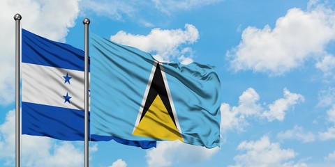 Honduras and Saint Lucia flag waving in the wind against white cloudy blue sky together. Diplomacy concept, international relations.
