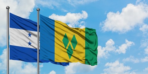Honduras and Saint Vincent And The Grenadines flag waving in the wind against white cloudy blue sky...