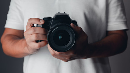 Photographer holding a digital camera - obrazy, fototapety, plakaty