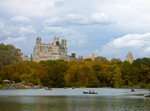 People row boats on The Lake in Central Park, New York City in autumn.