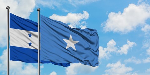 Honduras and Somalia flag waving in the wind against white cloudy blue sky together. Diplomacy concept, international relations.