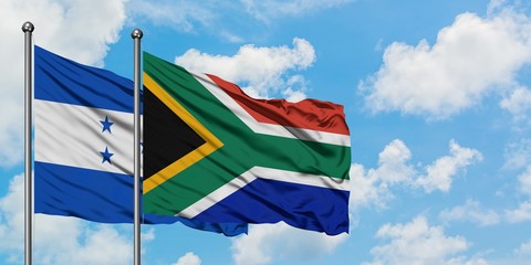 Honduras and South Africa flag waving in the wind against white cloudy blue sky together. Diplomacy concept, international relations.