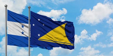 Honduras and Tokelau flag waving in the wind against white cloudy blue sky together. Diplomacy concept, international relations.