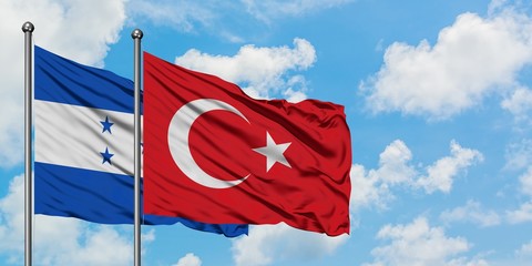 Honduras and Turkey flag waving in the wind against white cloudy blue sky together. Diplomacy concept, international relations.