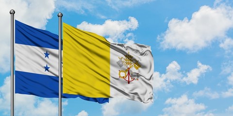 Honduras and Vatican City flag waving in the wind against white cloudy blue sky together. Diplomacy concept, international relations.