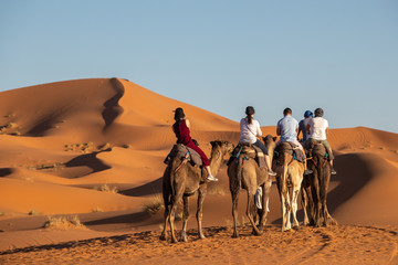 Fototapeta na wymiar European tourists in Sahara Desert during sunset, Merzouga, Morocco