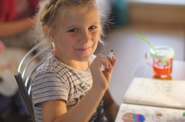 Cute little girl painting a picture in a home interior.