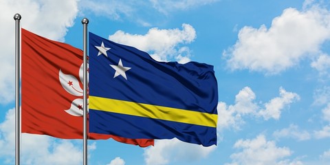 Hong Kong and Curacao flag waving in the wind against white cloudy blue sky together. Diplomacy concept, international relations.