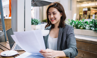 Smiling freelancer reading documents at cafe