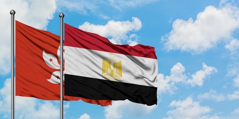 Hong Kong and Egypt flag waving in the wind against white cloudy blue sky together. Diplomacy concept, international relations.