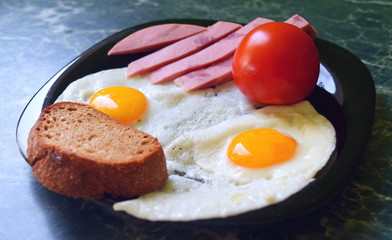 Breakfast. Fried eggs with tomato sausage and bread - from two eggs.