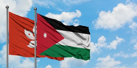 Hong Kong and Jordan flag waving in the wind against white cloudy blue sky together. Diplomacy concept, international relations.