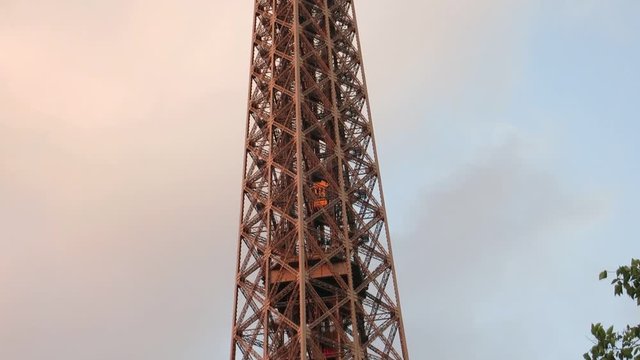 Beautiful scene of the elevator of Eiffel Tower at the sunset time, in Paris, France