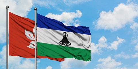 Hong Kong and Lesotho flag waving in the wind against white cloudy blue sky together. Diplomacy concept, international relations.