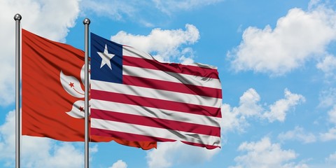 Hong Kong and Liberia flag waving in the wind against white cloudy blue sky together. Diplomacy concept, international relations.