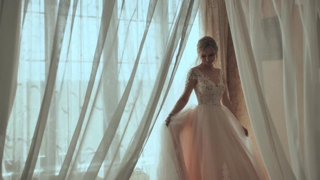 Happy bride is spinning at the window.