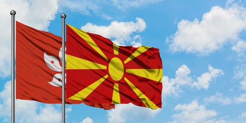 Hong Kong and Macedonia flag waving in the wind against white cloudy blue sky together. Diplomacy concept, international relations.