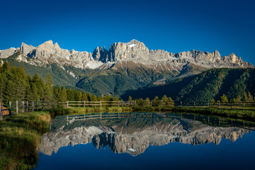Reflections of the Rosengarten mountains in the water of the Wuhnleger pond near Tiers