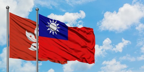 Hong Kong and Taiwan flag waving in the wind against white cloudy blue sky together. Diplomacy concept, international relations.