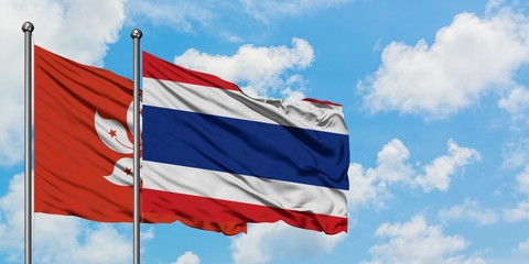 Hong Kong and Thailand flag waving in the wind against white cloudy blue sky together. Diplomacy concept, international relations.