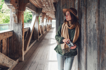 Young girl with a retro camera on a bridge