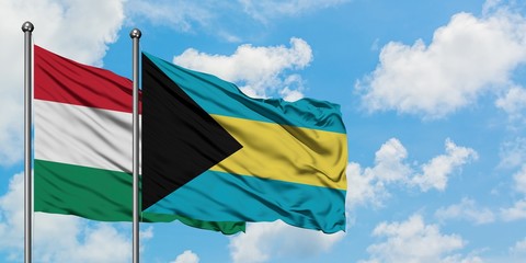 Hungary and Bahamas flag waving in the wind against white cloudy blue sky together. Diplomacy concept, international relations.