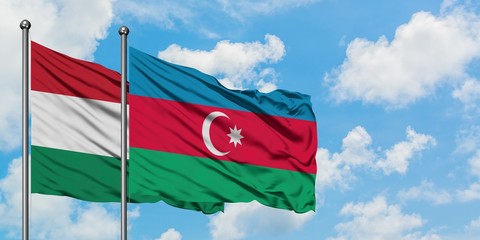 Hungary and Azerbaijan flag waving in the wind against white cloudy blue sky together. Diplomacy concept, international relations.