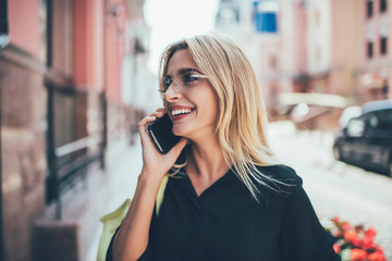 Sincerely female tourist feeling good during cellphone communication using contact application on cellular gadget, positive woman with cute smile talking via modern device, concept of generation