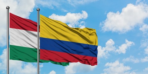 Hungary and Colombia flag waving in the wind against white cloudy blue sky together. Diplomacy concept, international relations.